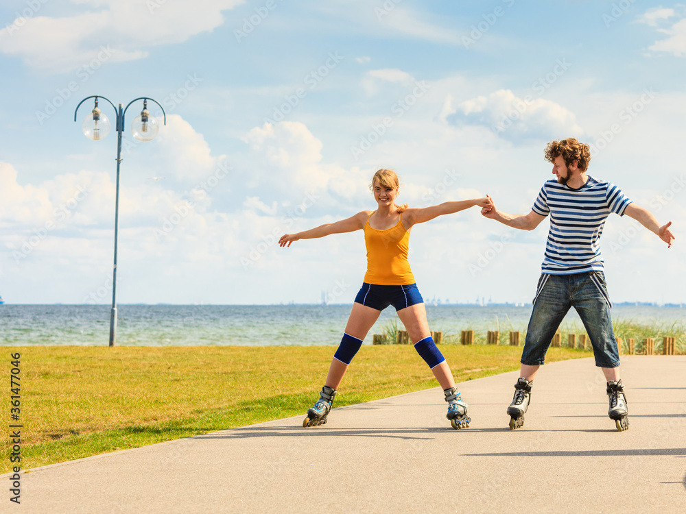 Young couple on roller skates riding outdoors