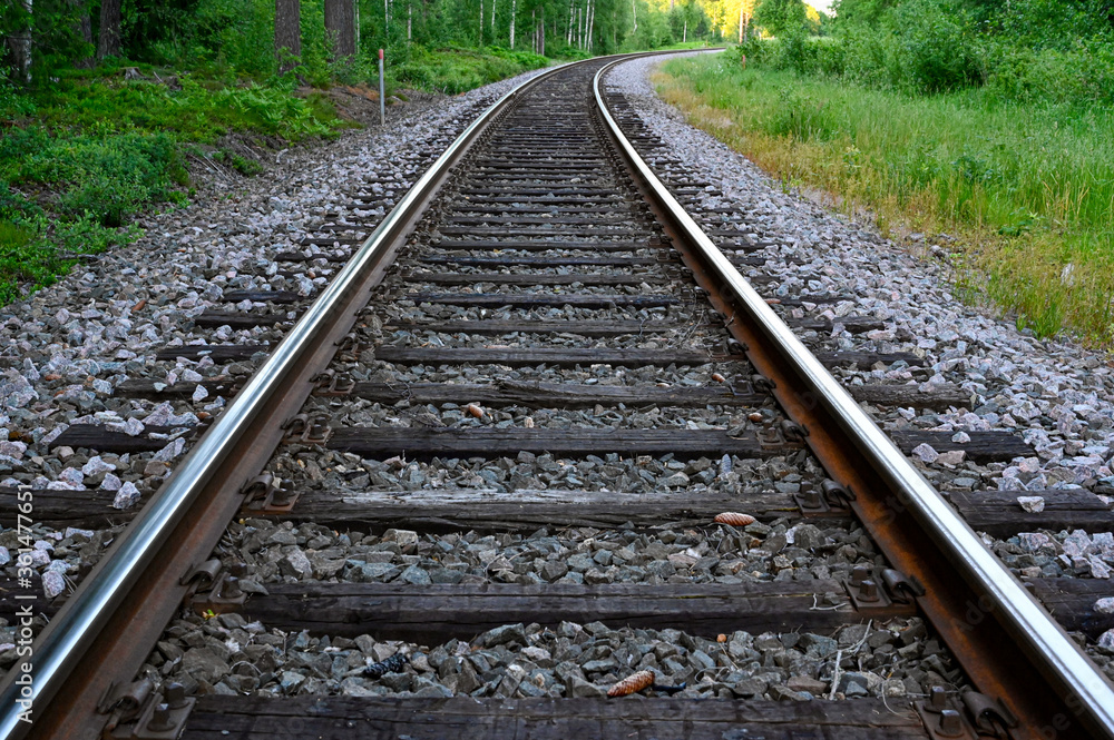Fototapeta premium low perspective of rail tracks into a bend