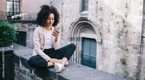 Young black tourist using smartphone on ancient street © GalakticDreamer