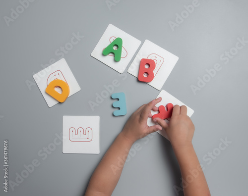 Concept of development and training of a child at home during the pandemic of coronavirus and COVID-19, Child's hands playing with alphabet blocks