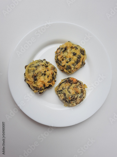 Rolade daun singkong, is a fried food from Indonesia. Made from cassava leaves, tofu and flour. Isolated in white background. photo