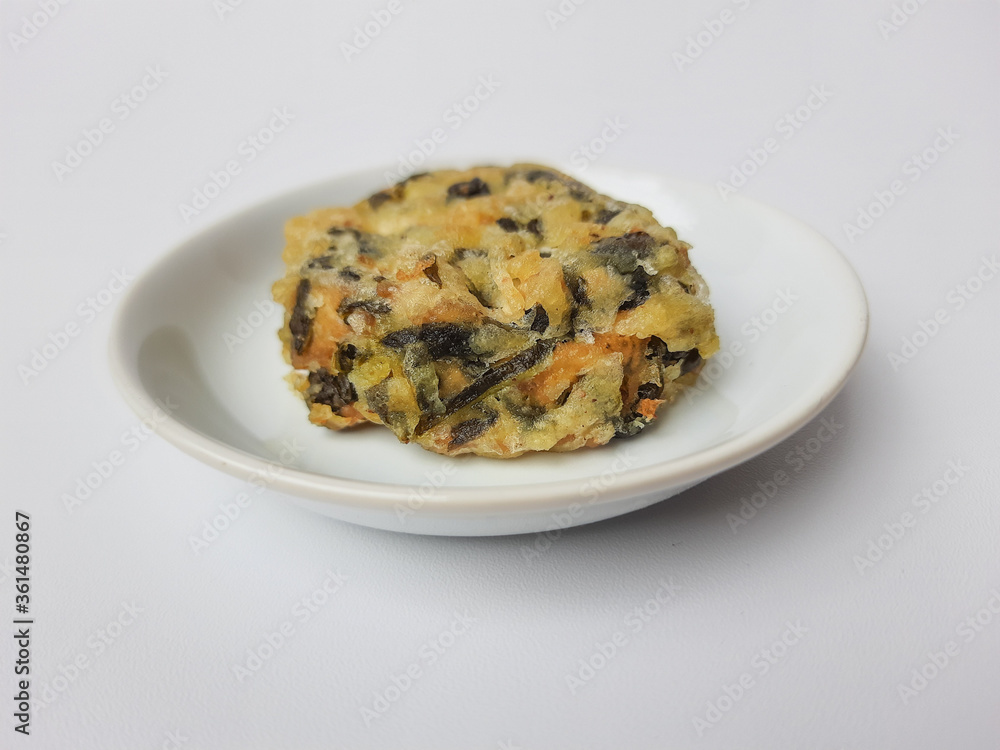 Fototapeta premium Rolade daun singkong, is a fried food from Indonesia. Made from cassava leaves, tofu and flour. Isolated in white background.