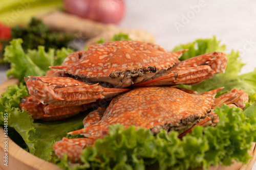 One crab is cooked on lettuce in a dish.