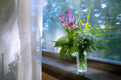 beautiful summer bouquet of wild flowers on the windowsill at home