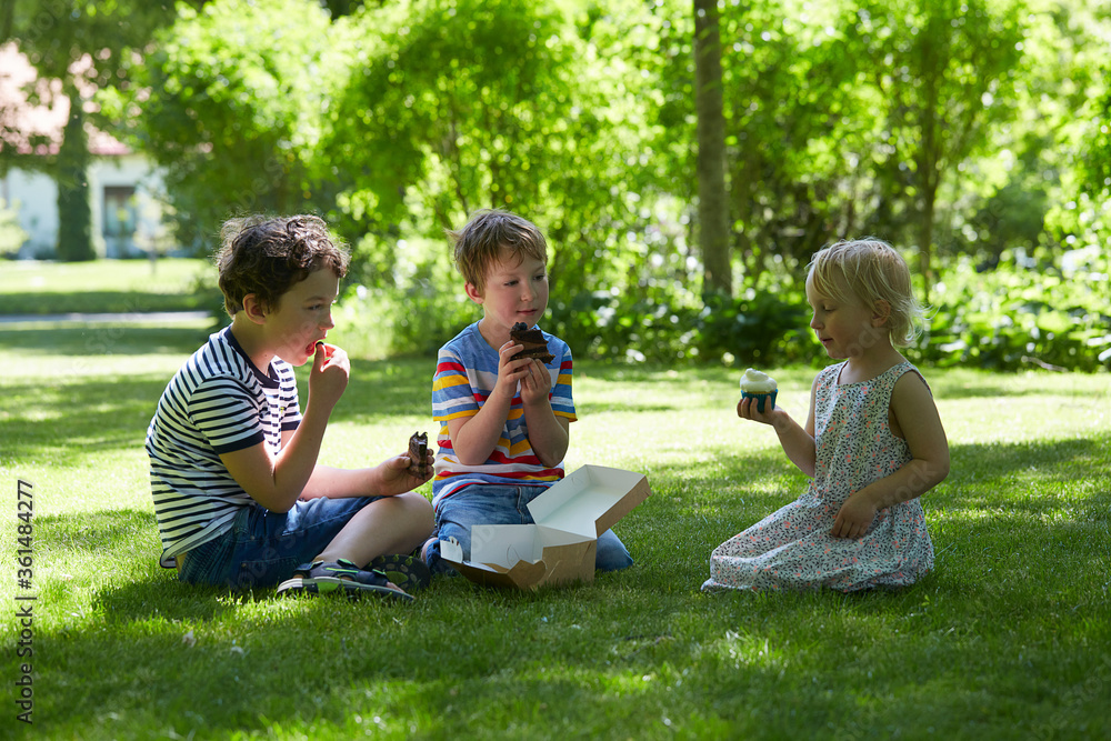kids are eating sweets in a park kids are eating sweets in a park