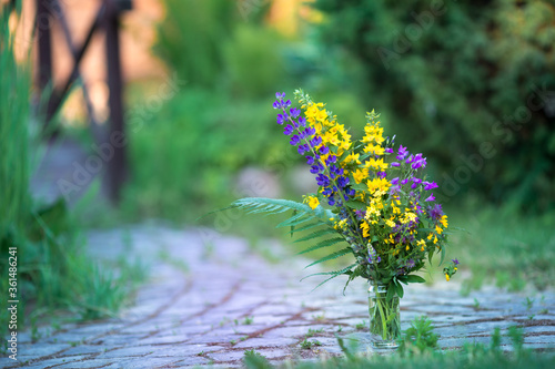 summer bouquet in a vase on the path in the garden