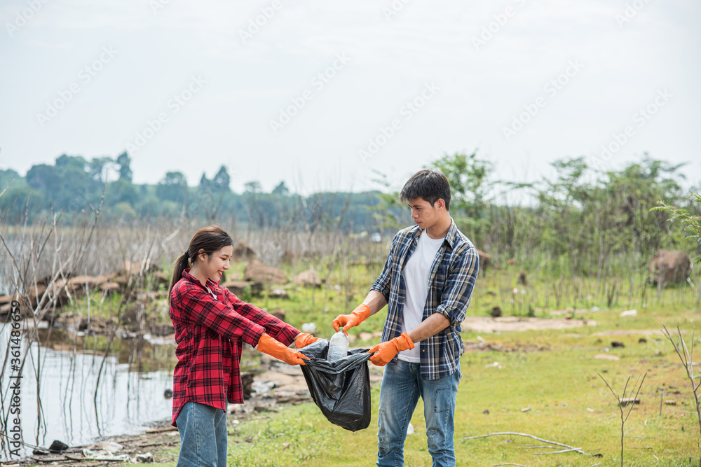 Men and women help each other to collect garbage. Men and women help each other to collect garbage.