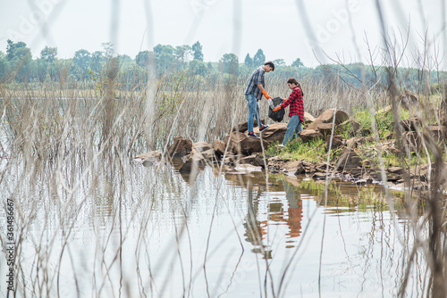 Men and women help each other to collect garbage.