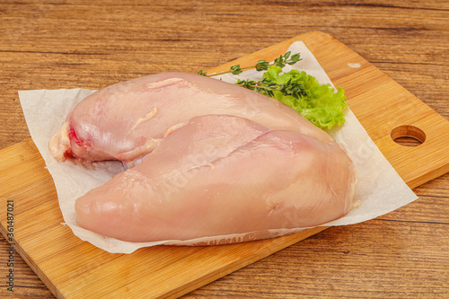 Raw chicken breast over board