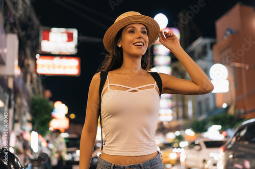 Photography Young brunette female solo traveler walking on city street in evening night in summer clothes