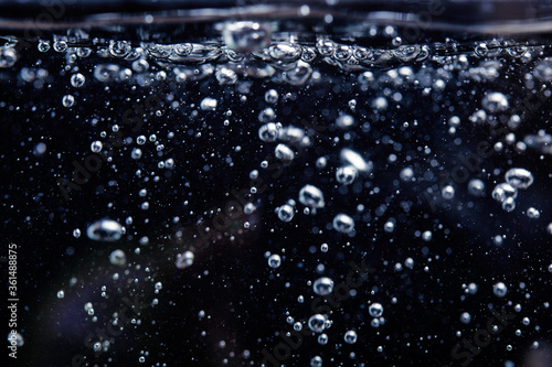 Air bubbles in the water, on a black background. the water begins to boil photo