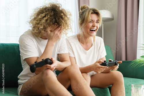 Two beautiful girls playing video game console in a living room