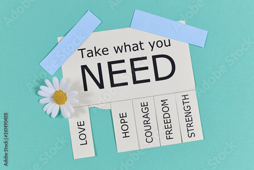 Tear-off stub note with text 'Take what you need' and words 'Love, Freedom, Hope, Courage' and 'Strength' with cute flowers on light teal blue background photo