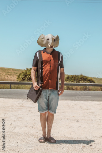 Imagen conceptual de un hombre con cabeza o mascara de elefante haciendo un descanso en el trabajo y tomando un aperitivo © minervaed