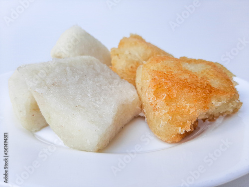 Jadah ketan, is a traditional snack from Indonesia. Made from sticky rice and grated coconut. Comparison before and after fried. On a white plate, isolated in white background