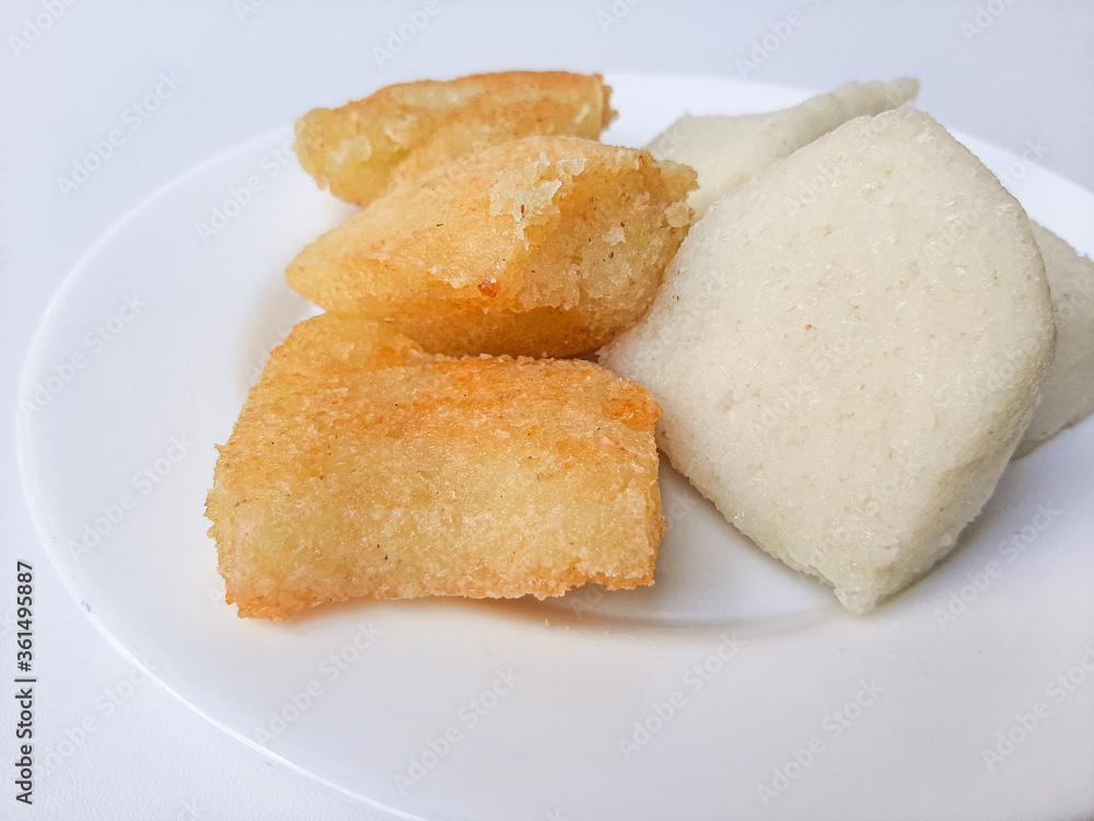 Jadah ketan, is a traditional snack from Indonesia. Made from sticky rice and grated coconut. Comparison before and after fried. On a white plate, isolated in white background Jadah ketan, is a traditional snack from Indonesia. Made from sticky rice and grated coconut. Comparison before and after fried. On a white plate, isolated in white background