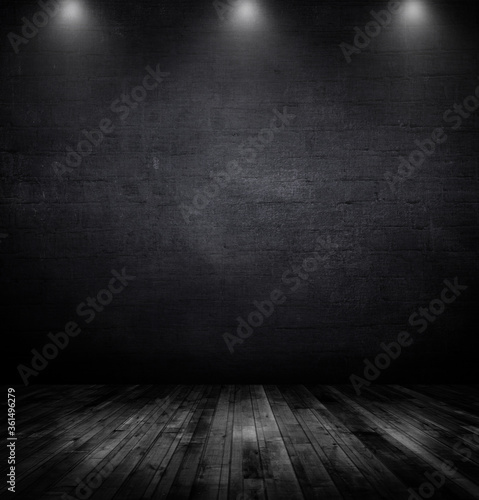 Wood table and black wall background with spotlights.