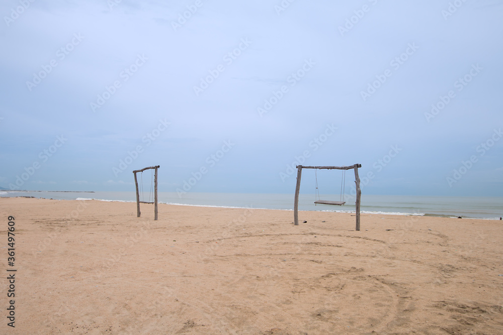 Empty wooden swing The pillars are made of wood and tied with a strong rope. On the beach in the southern part of Thailand, on a beautiful clear day Empty wooden swing The pillars are made of wood and tied with a strong rope. On the beach in the southern part of Thailand, on a beautiful clear day