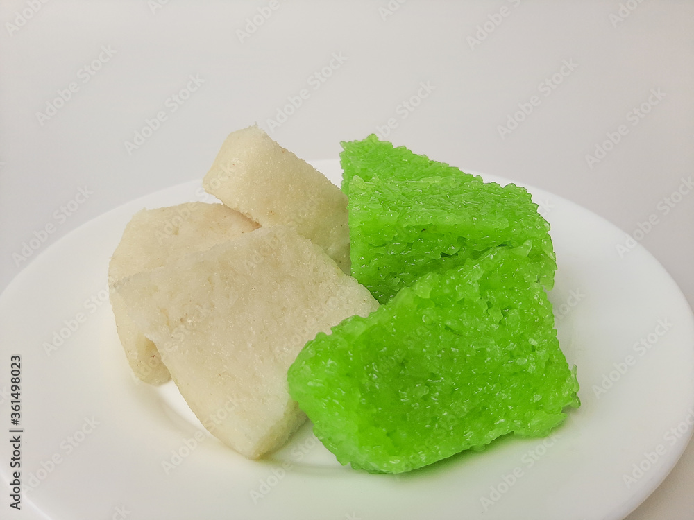 Jadah ketan (white) and wajik ketan (green), two traditional snacks from Indonesia. Made from sticky rice. On a white plate, isolated in white background Jadah ketan (white) and wajik ketan (green), two traditional snacks from Indonesia. Made from sticky rice. On a white plate, isolated in white background