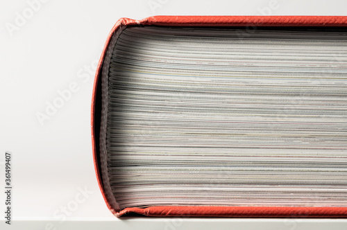 Closed book with red book cover. Close-up. Side view. photo