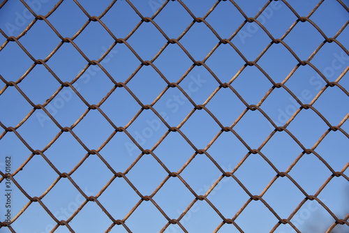 Metallic fence net against the sky