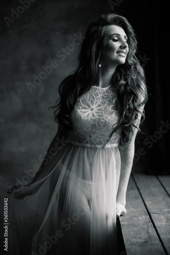 Morning of the bride. Sexy girl posing in white lace underwear. Portrait of a beautiful young female in a white underwear. Seductive woman in white linen and a peignoir.