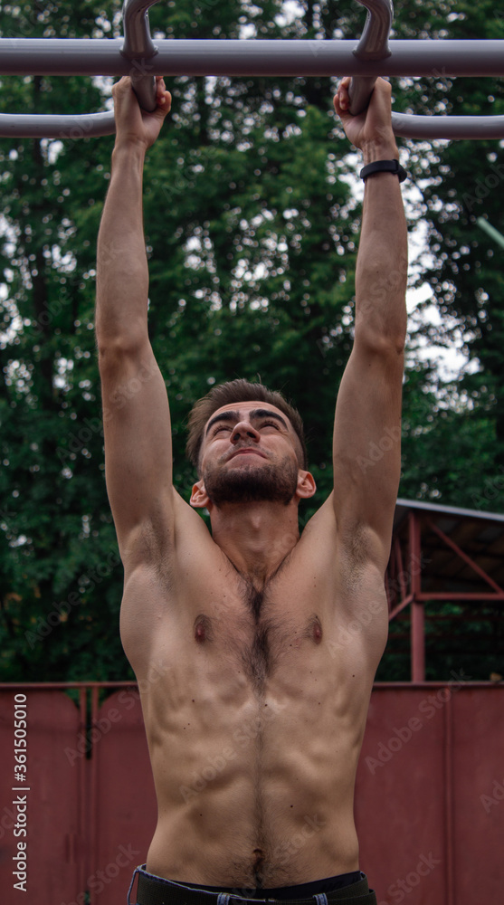 Athlete pulls up, performs strength exercise. Athlete pulls up, performs strength exercise.