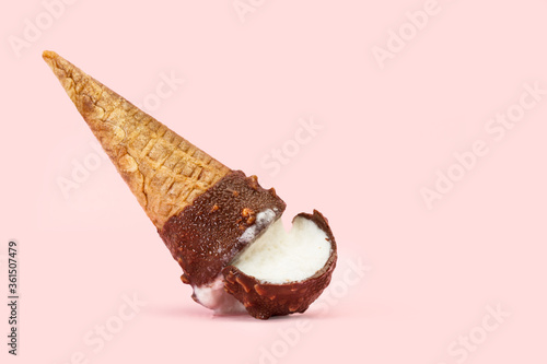 Cono de helado de chocolate y crema caído boca abajo sobre un fondo rosa pastel liso y aislado. Vista de frente. Copy space photo