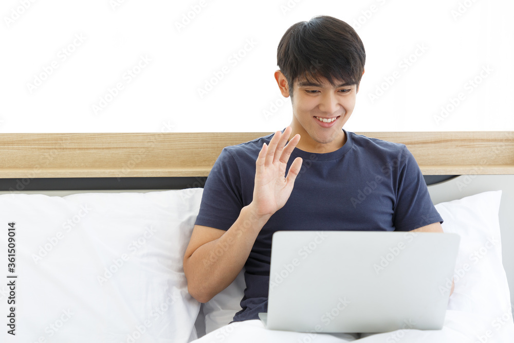 Happy man using Laptop computer video call in the Bedroom. COPY SPACE. Trading. Watching Movie. WORK FROM HOME WFH Concept. Happy man using Laptop computer video call in the Bedroom. COPY SPACE. Trading. Watching Movie. WORK FROM HOME WFH Concept.