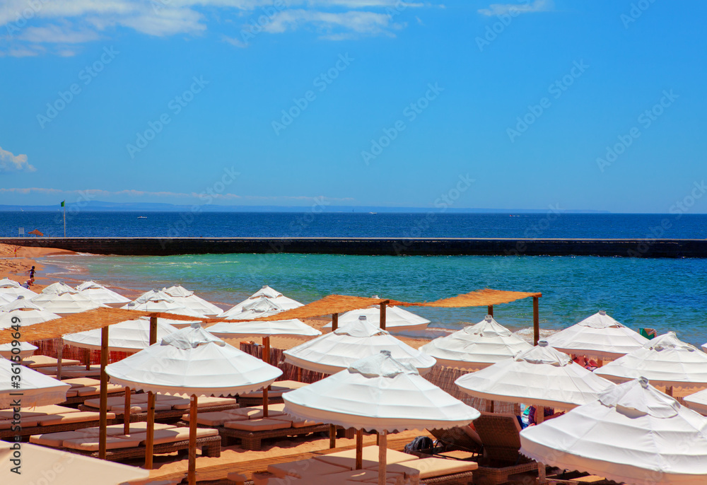 Beach with White Sun Umbrellas . Touristic Resort at the Atlantic Ocean Coast 