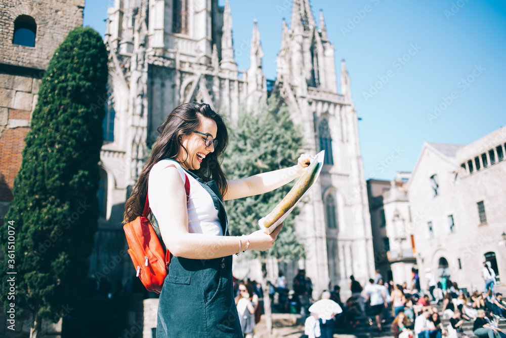 Delighted tourist reading map near old cathedral