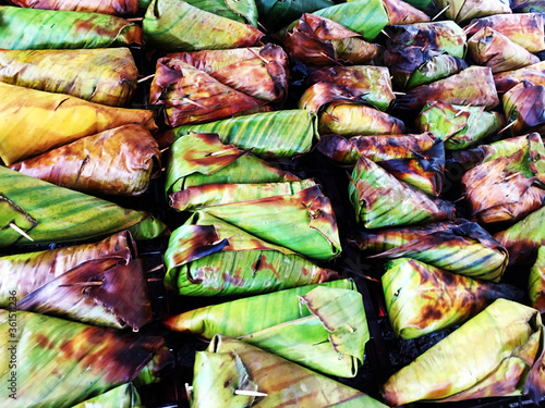 Street food. Sticky rice with banana on banana leaf Thai name is khao nieo ping. Vegetarian diet. Vegan dessert photo