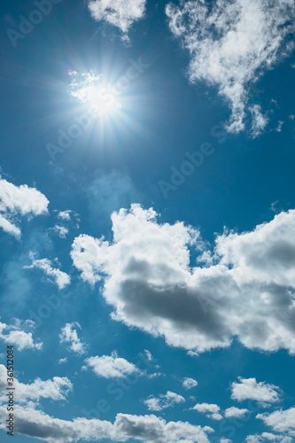 blue sky with white clouds and bright sun as a natural background