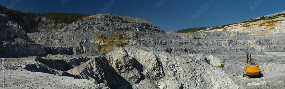 Panorama of limestone quarry in sunny weather against a blue sky. Panorama of limestone quarry in sunny weather against a blue sky.