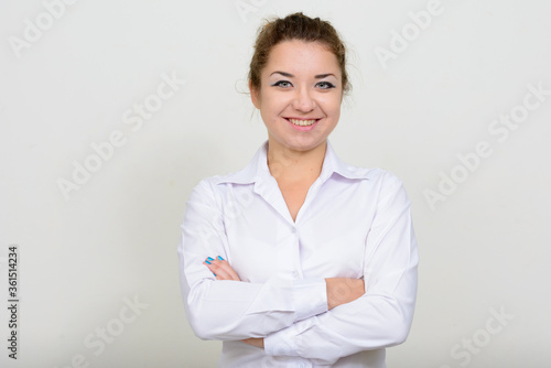 Portrait of happy young beautiful businesswoman smiling with arms crossed