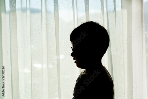 Silhouette of a boy in front of the window