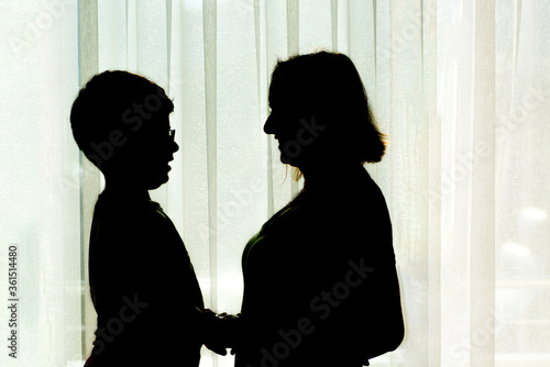 Silhouette of a happy mother and son © sezer66