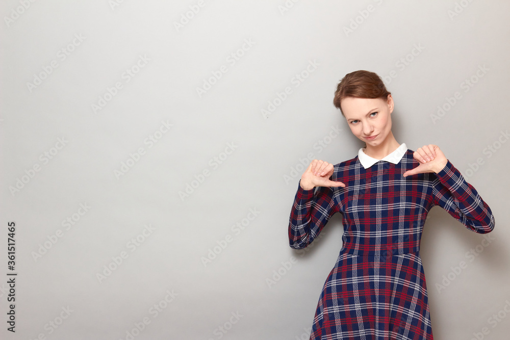 Portrait of proud and successful girl pointing with thumbs at herself Portrait of proud and successful girl pointing with thumbs at herself