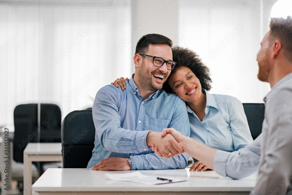 Portrait of a happy couple handshake with investment adviser. Portrait of a happy couple handshake with investment adviser.