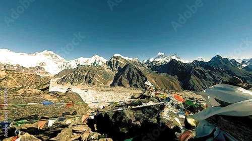 360 VR Gokyo Ri mountain top. Tibetan prayer Buddhist flag. Wild Himalayas high altitude nature and mount valley. Rocky slopes covered with ice. Panorama movement