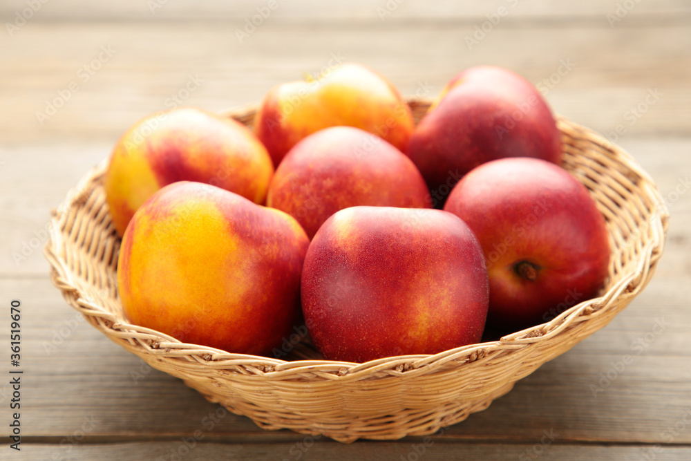 Nectarines in a basket on brown background with copy space Nectarines in a basket on brown background with copy space