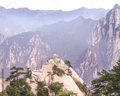 Beautiful landscape shot of the Huashan Mountain in Huayin, China on a foggy day photo