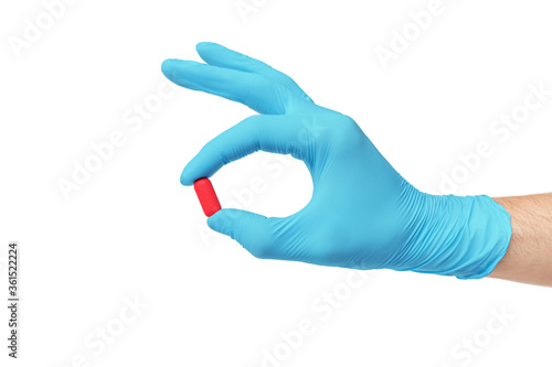 Red pill in the hands of a doctor. Concept of development research and testing of the latest antiviral drug.