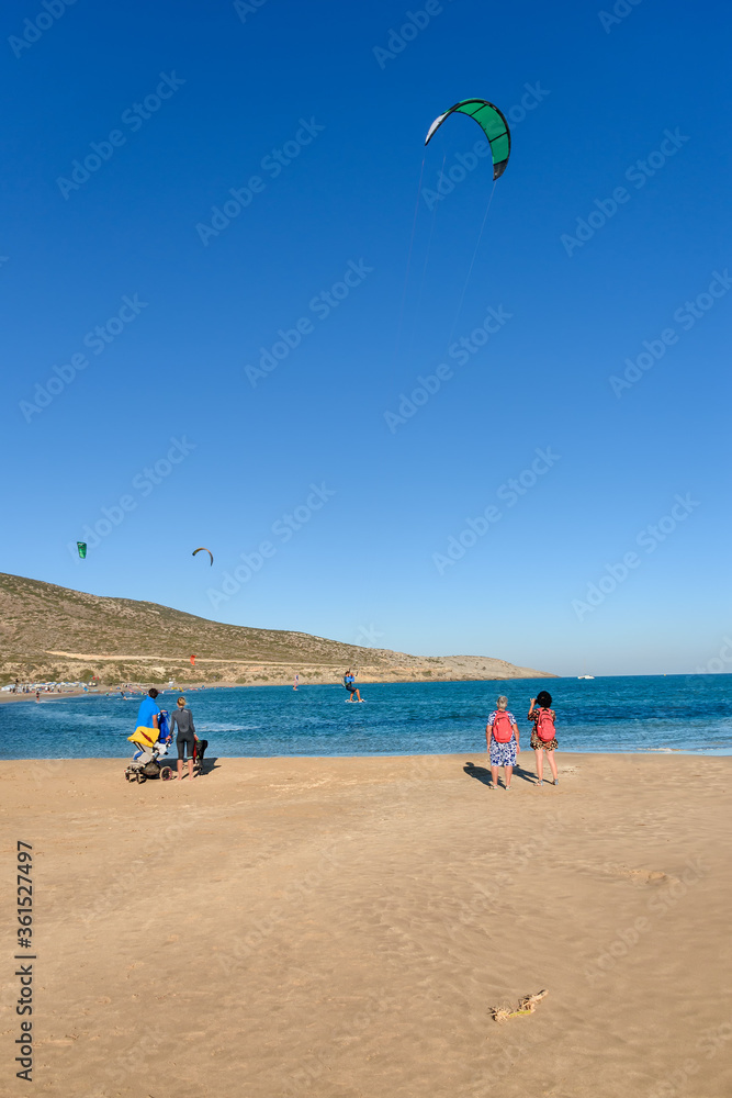People watching kitesurfers surfing on Prasonisi beach (Rhodes, Greece)