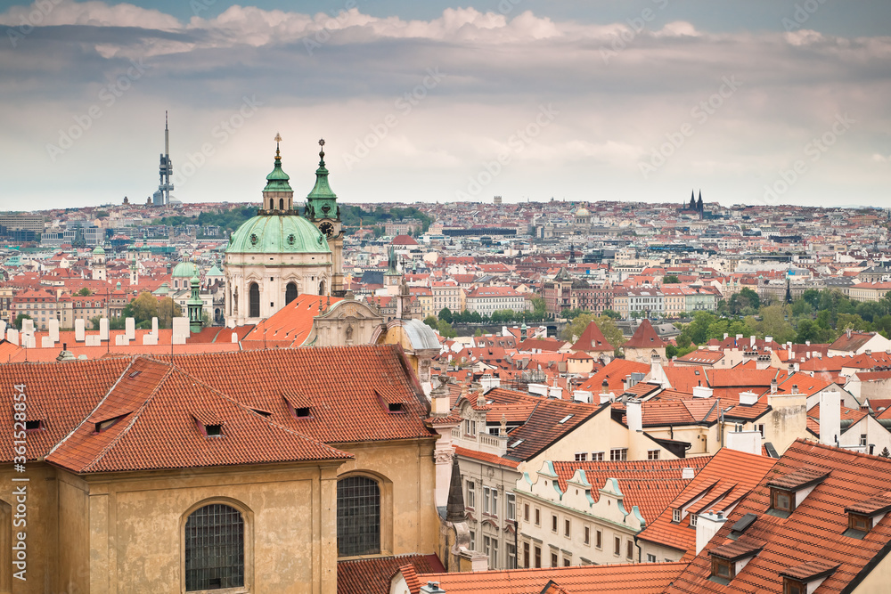 View of red roofs of Prague along with St. Nicholas church and Zizkov tower