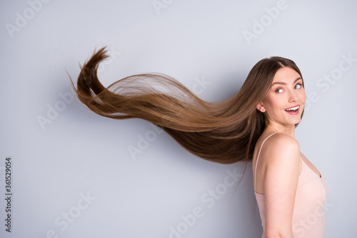 Close-up profile side view portrait of her she nice-looking attractive pretty cheerful well-groomed brown-haired girl wind blowing silky flawless hair isolated on light gray pastel color background photo