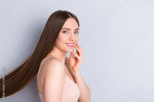 Profile photo of charming appearance model lady demonstrating ideal neat long hairstyle touch hand cheekbone wear beige singlet isolated grey color background