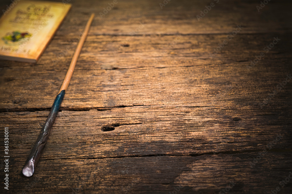 Obraz premium Magic wand on wooden table, Magic wand Wizard tool on vintage wooden background.