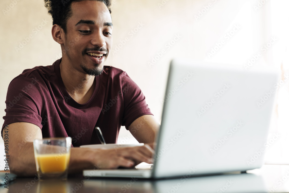 Photo of african american man working with laptop while having breakfast Photo of african american man working with laptop while having breakfast