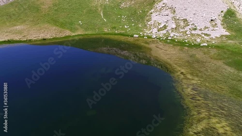 Aerial drone video from iconic and beautiful lake Drakolimni of Tymfi mountain which resides at high altitude above sea, Vikos National Park, Zagori, Greece photo